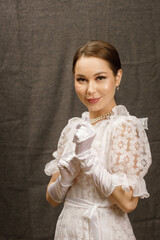 a girl in a white dress and white gloves on a gray background