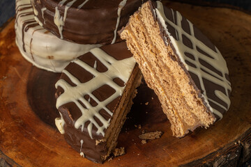 Alfajor cut in half, typical candy from Argentina, on a wooden board.