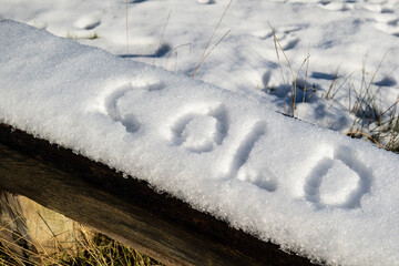 The word "cold" written on the snow