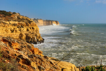 Waves in the Atlantic Ocean heading toward cliffs on a windy winter day in Carvoeiro, Portugal.
