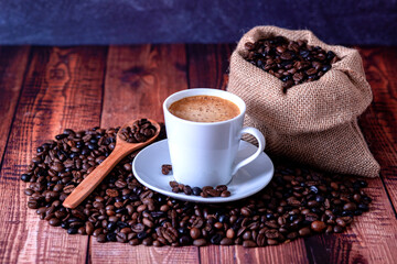 coffee beans on wooden table with coffee cup and wooden spoon