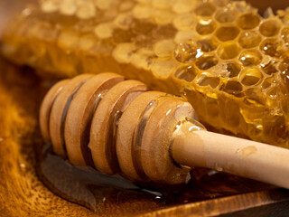 With honeycombs and a wooden spoon for honey in a wooden cup. Honeycombs and honey.