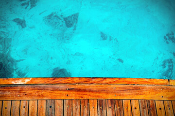 Wooden floor of the yacht is made of old brown wooden boards. Blue transparent deep sea. Background.