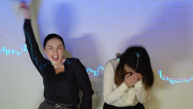 Two funny woman traders dance against the background of cryptocurrency chart
