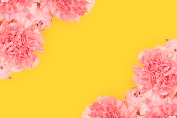 Pink carnation and rose flowers on a yellow background. Place for text.