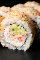 selective focus on the filling of california roll with snow crab meat garnished with sesame seeds.