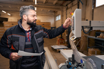 Adult male working in the woodhouse manufactory © Viacheslav Yakobchuk