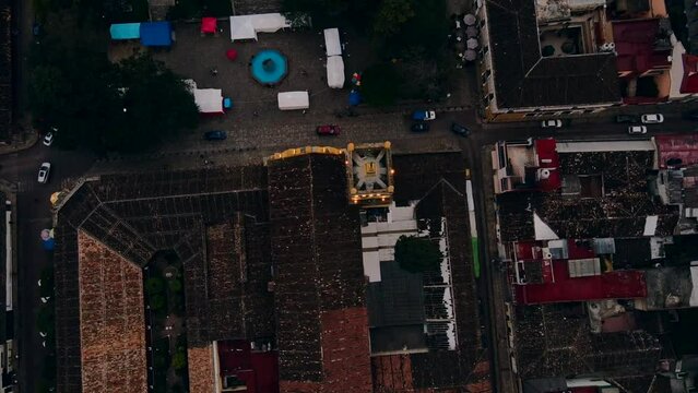 Toma cenital de dron hacia una iglesia mientras autos pasan frente ella