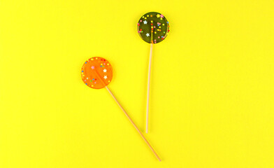 Two round lollipops on a yellow background