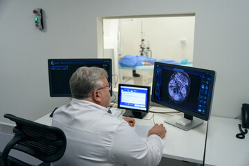 Fototapeta na wymiar Elderly doctor looks into the monitor of diagnostic equipment