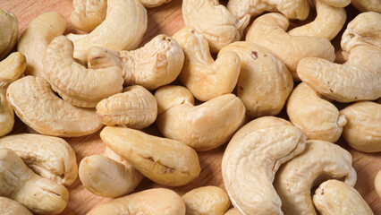 lots of cashew nuts scattered on a wooden board