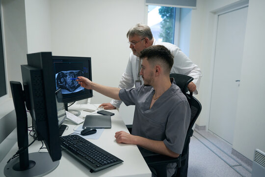 Colleagues of traumatologists analyze results of MRI in diagnostic room