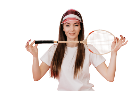 Satisfied Young woman with loose hair in white t-shirt and transparent visor, smiling looking at camera, holding badminton racket against studio transparent background. Sport healthy lifestyle.