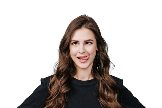 Playful brunette young woman in black sweater shows tongue, squinted eyes over transparent background at studio. Close up portrait of hispanic girl with mad face expression. Having fun, joking. Drunk