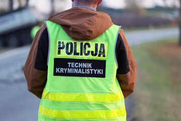 Technik kryminalistyki - policjant w żółtej kamizelce na służbie.  - obrazy, fototapety, plakaty