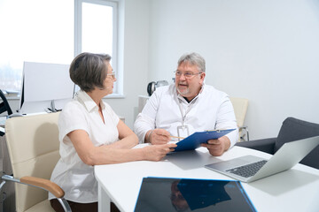 Obraz premium Elderly woman communicates with a doctor in his office