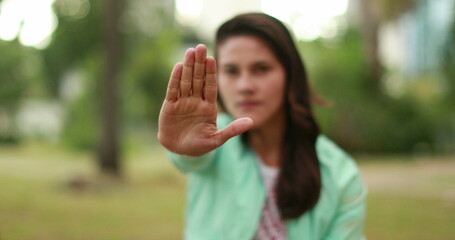 Millennial girl rejecting with hand blocking symbol