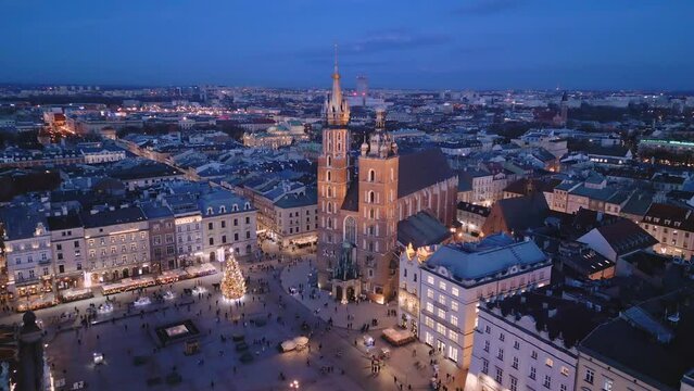 Kości&oacute;ł Mariacki - lot dronem w nocy wok&oacute;ł wież kościoła nad Rynkiem Gł&oacute;wnym w Krakowie. W tle zamek na Wawelu i Sukiennice.
