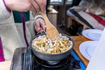 Two hands of man cooking outdoors.