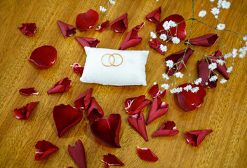 wedding rings and rose petals seen from above