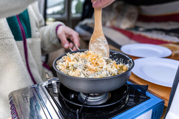 Two hands of man cooking outdoors.