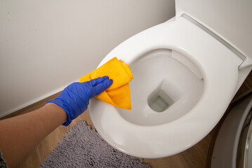 The woman hand removing dirty from toilet top, cleaning