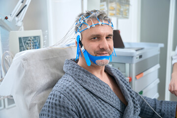 Man undergoes an EEG examination - electroencephalography in medical clinic