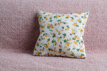 Soft,floral pattern cushion on pink sofa