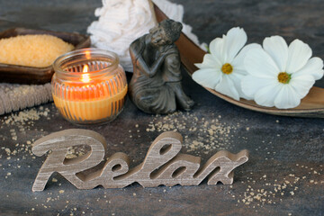 Buddha und brennende Kerzen mit dem Schriftzug Relax. Konzept der Ruhe und Entspannung.