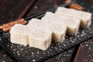 Asian dessert maki sushi close-up - Roll with fruits and cream cheese with coconut flakes