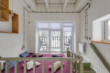 Large bright room with a bed on the floor and views of the forest