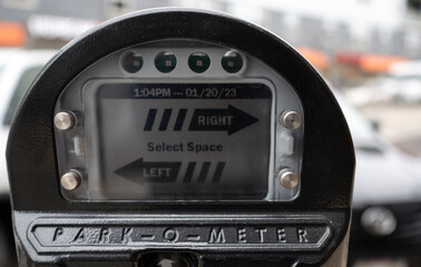 A closeup of a digital parking meter on a busy street