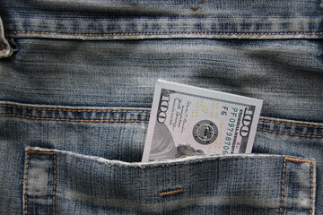 Dollar bills in a back pocket of jeans.