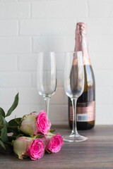 Valentine's day concept. roses, a bottle of champagne, on a dark wooden background.