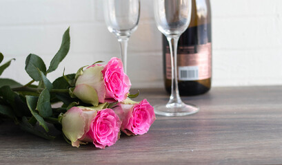 Valentine's day concept. roses, a bottle of champagne, on a dark wooden background.