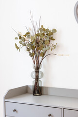 Bouquet d'eucalyptus posé sur la commode de la chambre