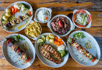 Skewer mixed grilled meat on plate with vegetables salad rice potato cusida. traditional food. Skewer fish