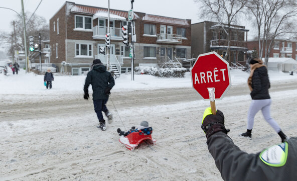 Brigadier scolaire faisant son travail pendant une averse de neige