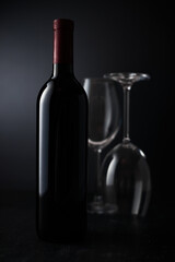 Glasses and bottle of wine on dark background