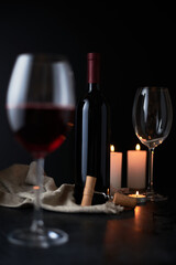 Glasses and bottle of wine on dark background