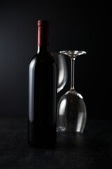 Glasses and bottle of wine on dark background