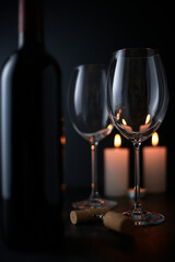 Red wine is poured into a glass from a bottle on a blurred background, a stream of red wine from the bottle swirls in the glass, close-up. Free space for text.