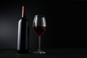 Obraz na płótnie Canvas Glasses and bottle of wine on dark background