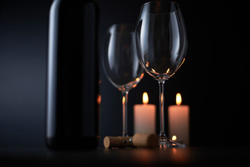 Red wine is poured into a glass from a bottle on a blurred background, a stream of red wine from the bottle swirls in the glass, close-up. Free space for text.