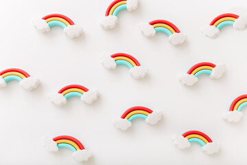 Rainbow erasers with smiling clouds on white background, top view