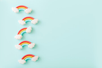 Rainbow erasers with smiling clouds on color background, top view