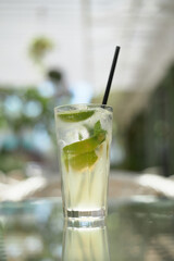 Summer mint refreshing mojito cocktail with ice in a glass outdoors in a cafe.