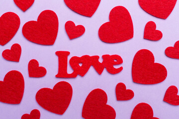 Felt word love with hearts on color background, top view