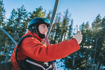 A boy taking a selfie on a chairlift.