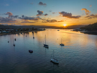 Aerial sunrise waterscape with boats and scattered clouds